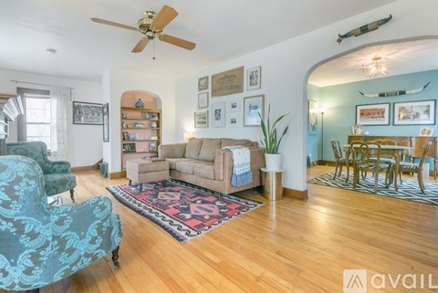 A living room with a blue patterned chair and a rug.