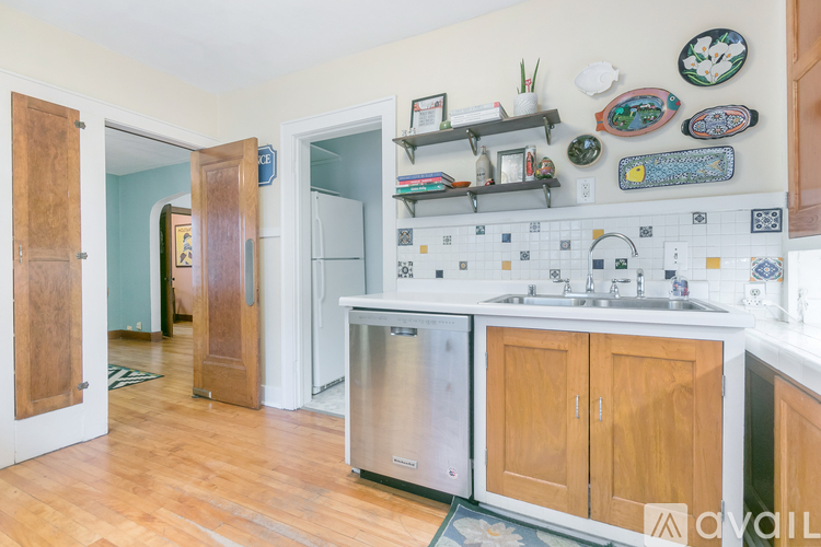 A kitchen with wooden cabinets and a stainless steel refrigerator.