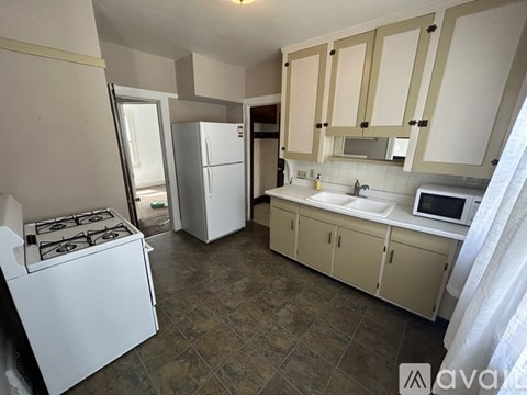A kitchen with a stove, refrigerator, and cabinets.