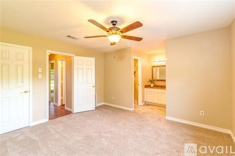 A spacious room with a ceiling fan and carpeted floor.
