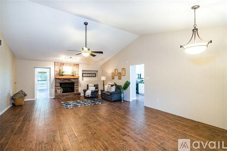 A living room with a fireplace and a ceiling fan.