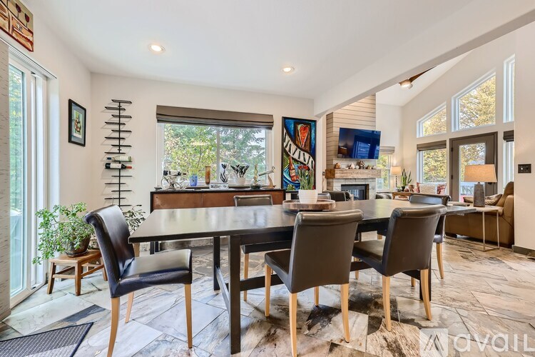 A modern dining room with a wooden table and chairs.