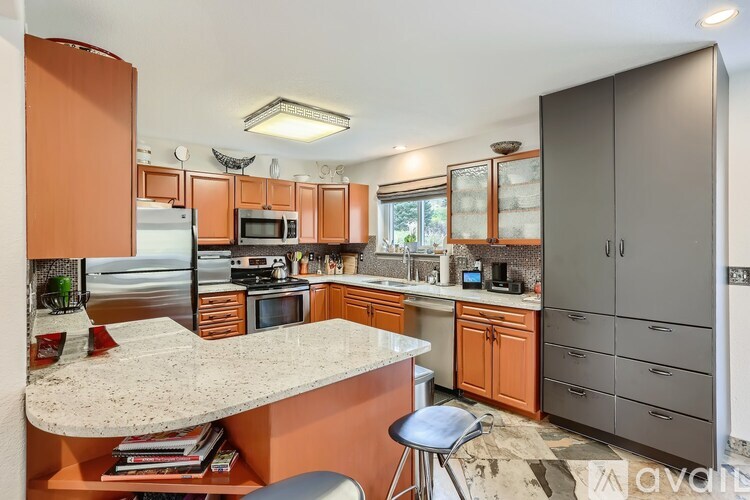 A kitchen with a marble countertop and a bar stool.
