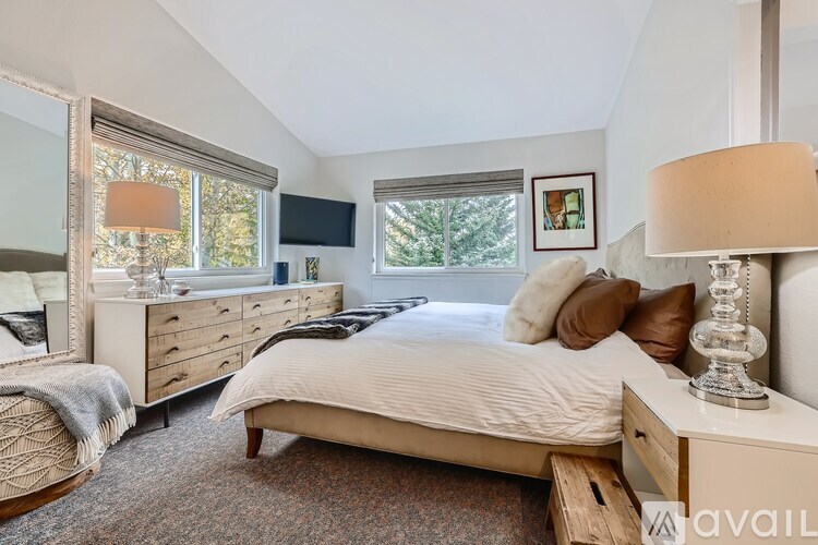 A bedroom with a large bed, a dresser, and a mirror.