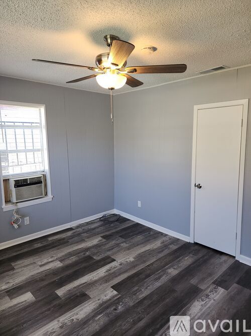 A room with a ceiling fan and a window with blinds.