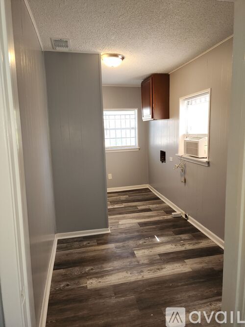 A room with wooden flooring and a window.