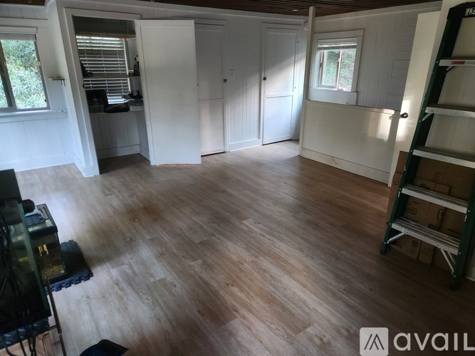 A room with wooden flooring and white walls.