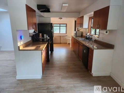A kitchen with wooden cabinets and a black fridge.