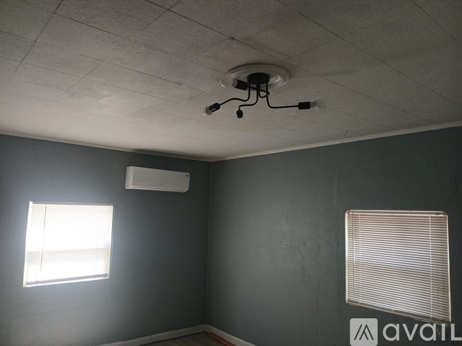 A room with grey walls and a window with blinds.