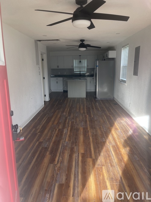 A room with wooden floors and a ceiling fan.