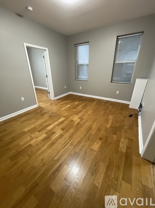 A room with wooden flooring and a white door.