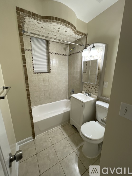A bathroom with a toilet, tub, and sink.