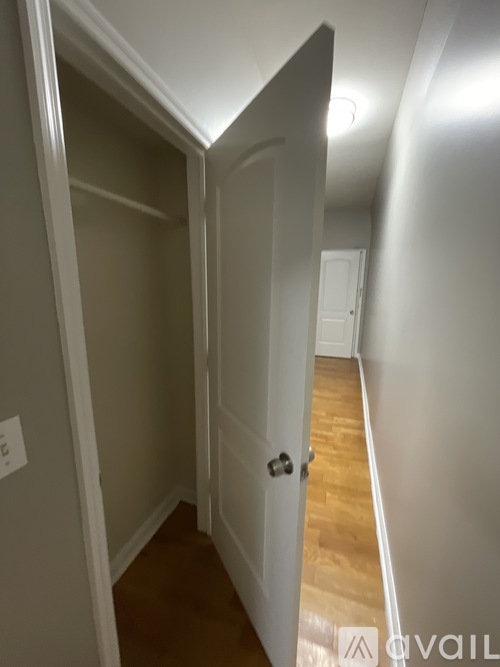 A hallway with a door on the right and a wall on the left.