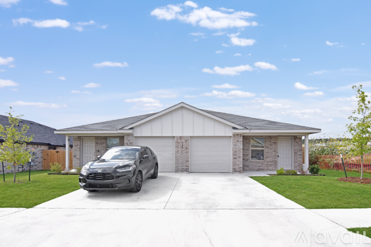 A black car is parked in front of a house.