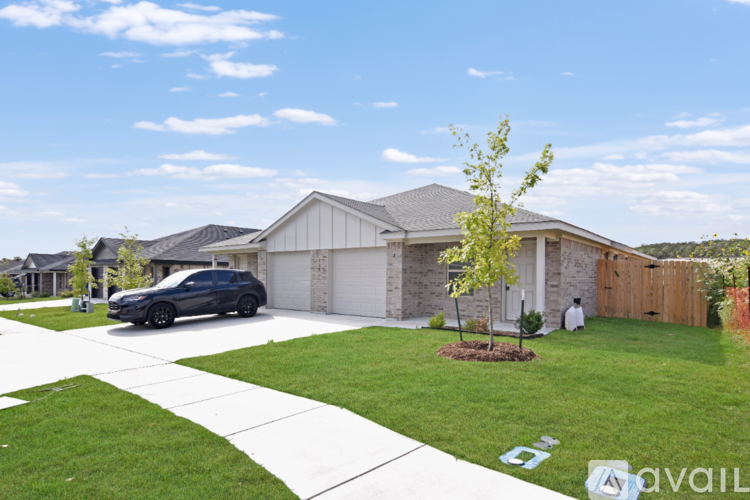 A house with a car parked in front and a tree in the front yard.