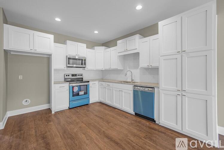 A kitchen with white cabinets and a blue dishwasher.