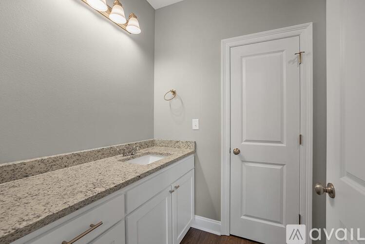 A bathroom with a sink, a mirror, and a door.