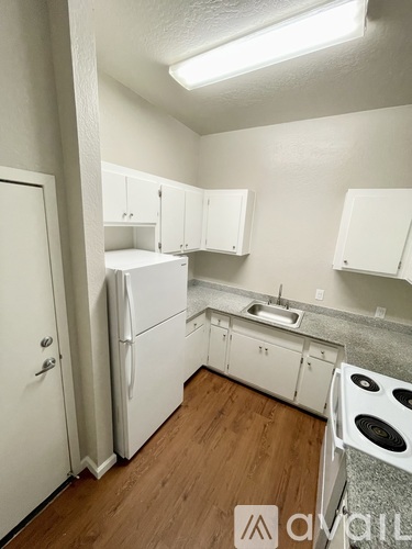 A kitchen with white appliances and cabinets.