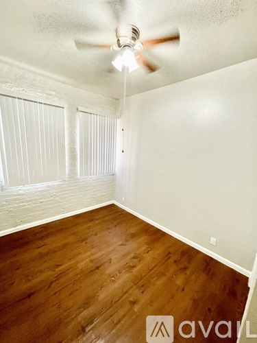 A room with wooden floors and a ceiling fan.