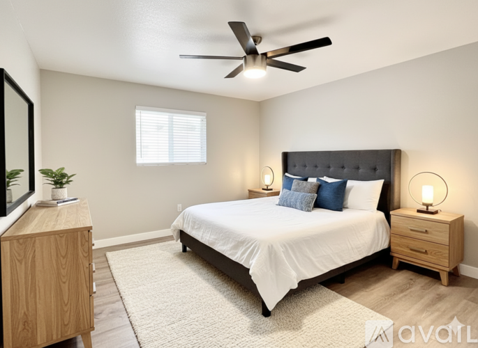 A bedroom with a bed, nightstand, and a ceiling fan.