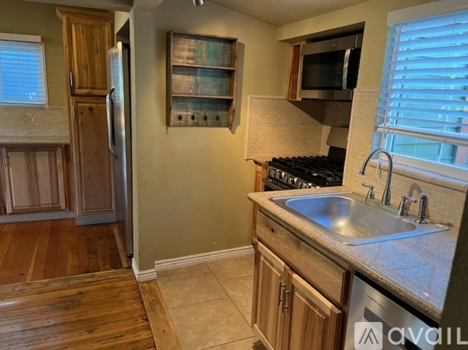 A kitchen with wooden cabinets and a stainless steel refrigerator.