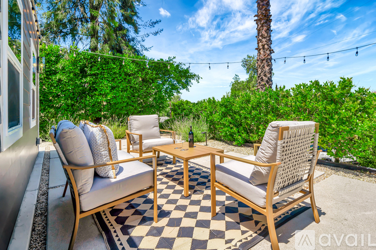 A patio with a checkered floor and a wooden table with chairs.