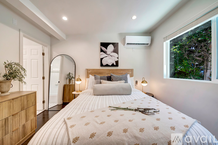 A bedroom with a large bed and a mirror on the wall.
