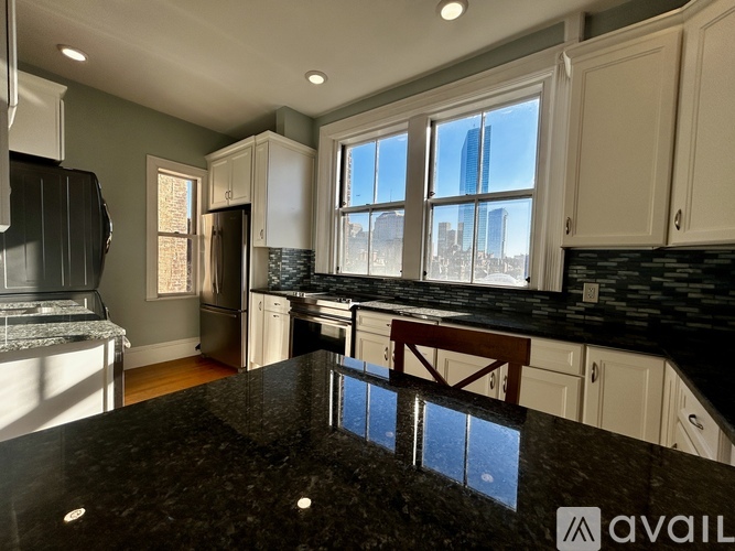 A kitchen with granite countertops and a view of a city skyline.