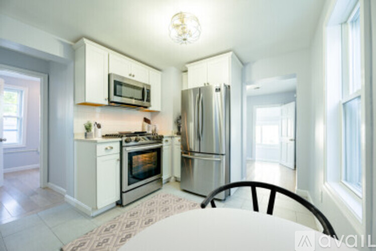 A kitchen with a fridge, oven, and microwave.