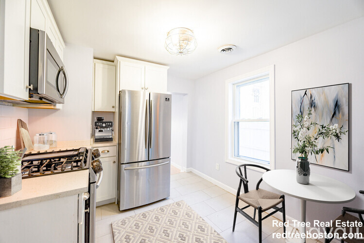 A kitchen with a refrigerator, stove, and microwave.