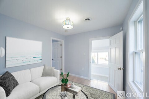A living room with a white couch and a glass table.