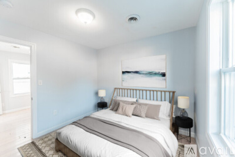 A bedroom with a large bed and a painting on the wall.