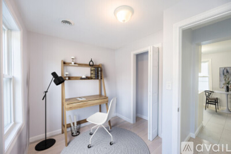 A room with a desk, chair, and a mirror.