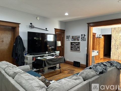 A living room with a grey couch and a black television.