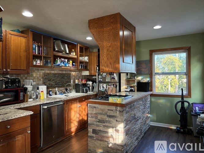 A kitchen with wooden cabinets and a stone counter.
