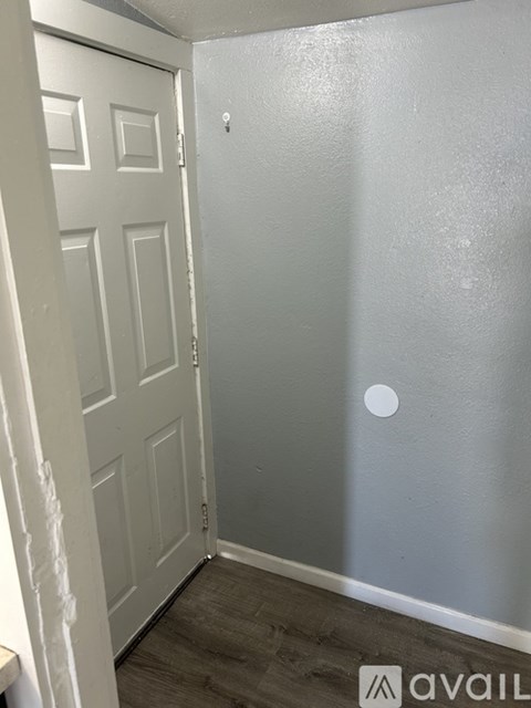 A white door is in a room with a grey wall.