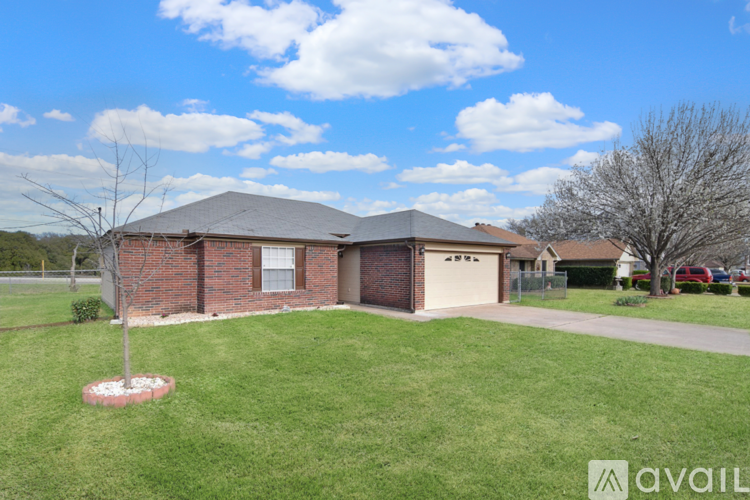 A house with a brown brick exterior and a white garage door is for sale.