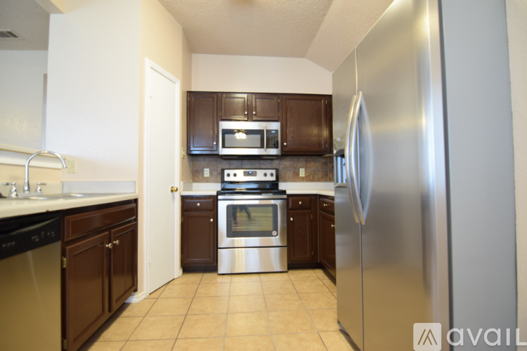 A kitchen with a refrigerator on the right side.
