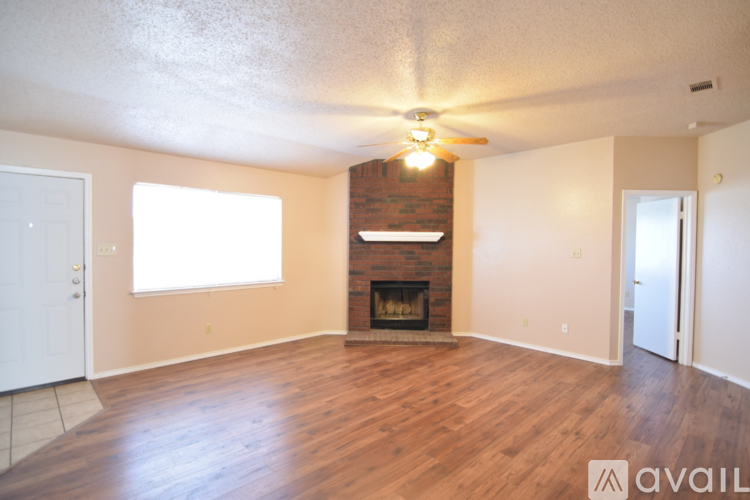 A living room with a fireplace and a ceiling fan.