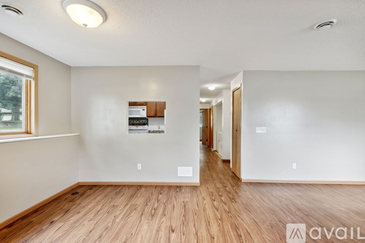 A spacious room with wooden floors and white walls.