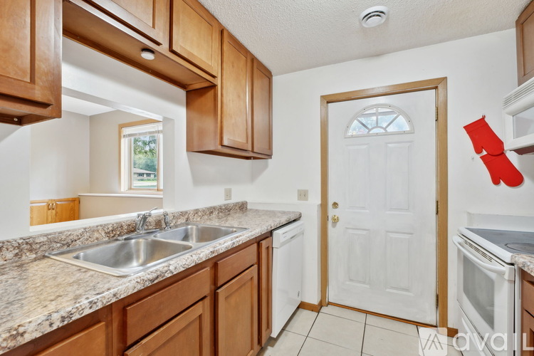 A kitchen with wooden cabinets and a white door.