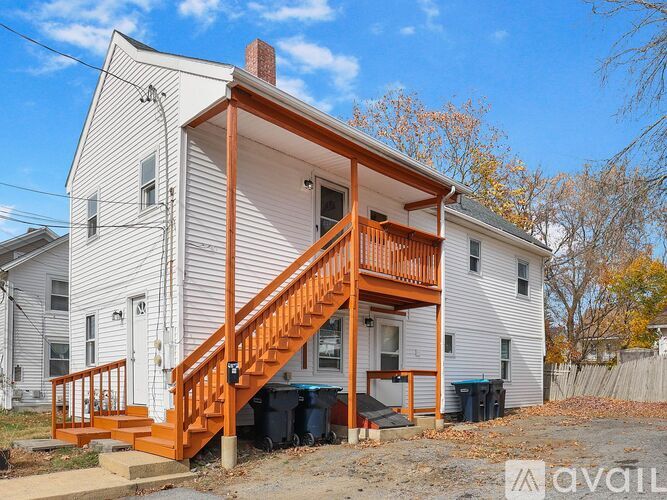 A two-story house with a wooden staircase leading to the upper floor.