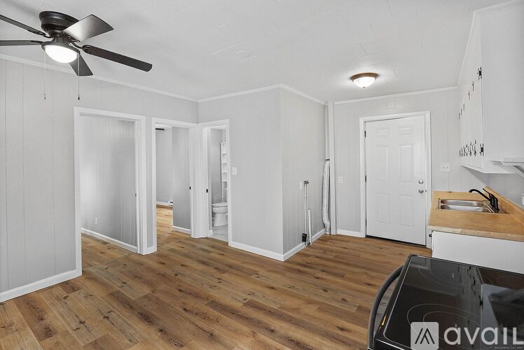 A room with a ceiling fan and wooden flooring.