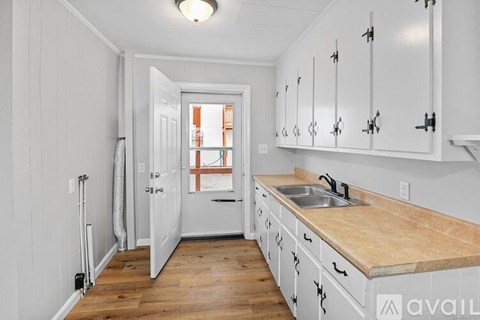 A kitchen with white cabinets and a wooden counter top.