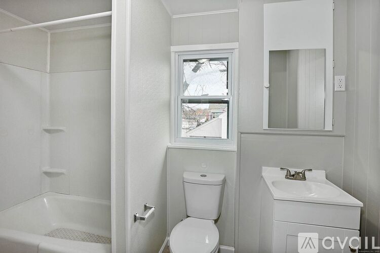 A white bathroom with a toilet, sink, and bathtub.