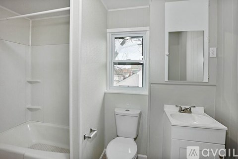 A white bathroom with a toilet, sink, and bathtub.