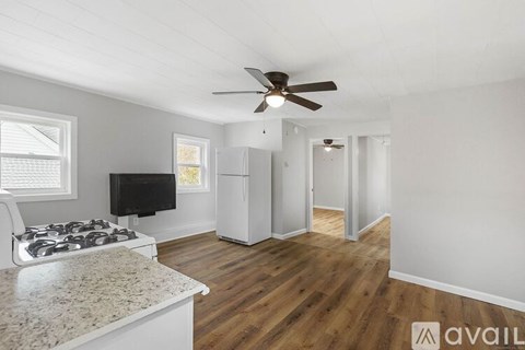 A kitchen with a stove top oven and a fan on the ceiling.
