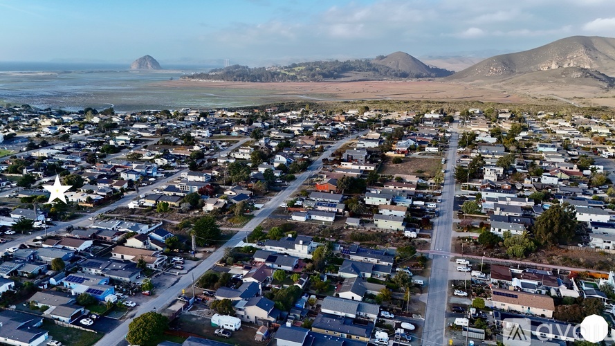 A small town with a road running through it and mountains in the background.