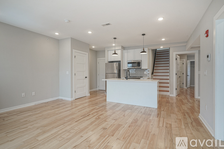 A spacious kitchen with wooden flooring and a white island.