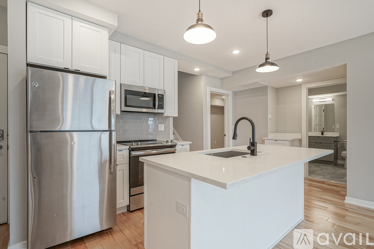 A modern kitchen with a stainless steel refrigerator and white countertops.